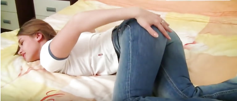 Porn image Une petite salope en jeans se touche sur son lit